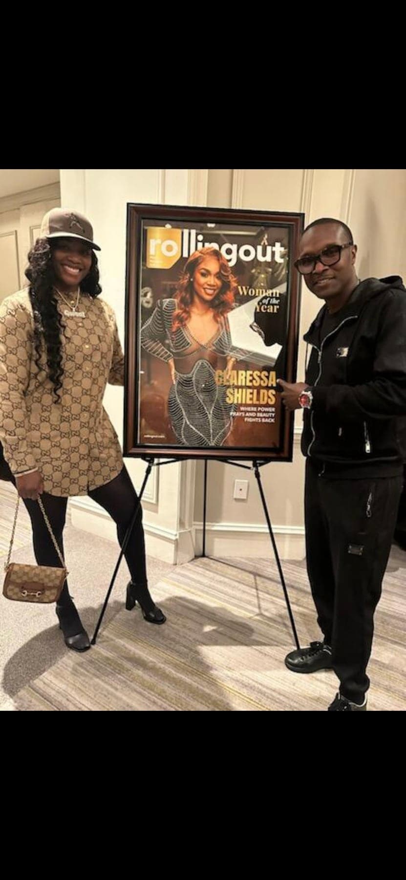 Ric Mathis with Claressa Shields beside a display of her Rolling Out cover